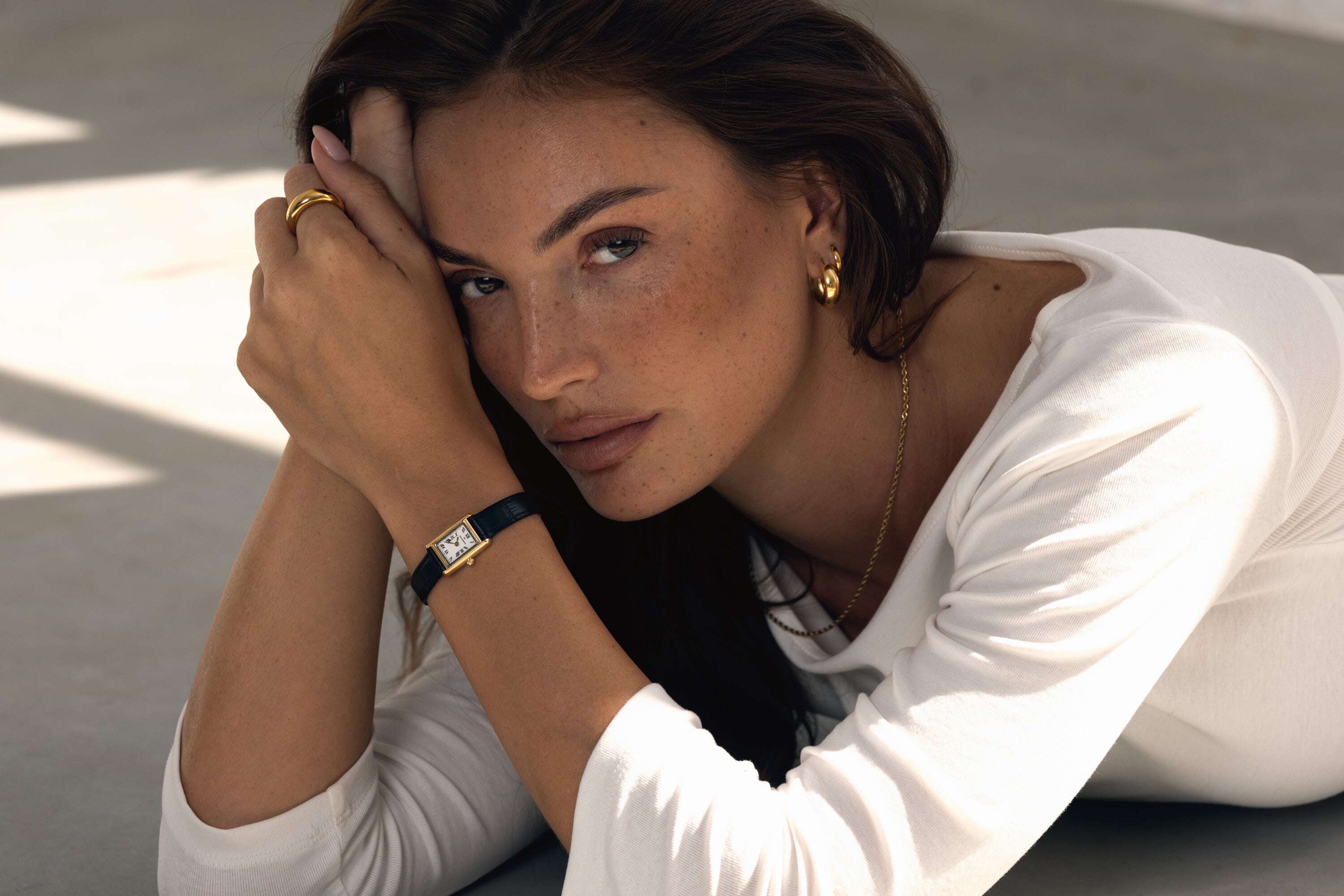 Mockberg giveaway: model wearing a gold watch with black leather strap